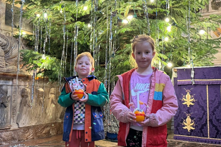 Two youngsters holding the Christingles they made.  AQ 0631
