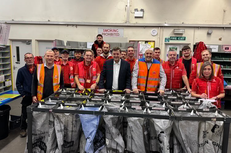 Mel Stride, centre, with Dave Wright, centre left and Rob Foster, centre right, with some of the Crediton Royal Mail Sorting Office staff. AQ 0377