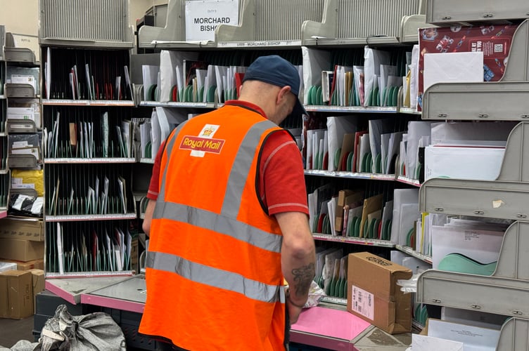 A Royal Mail worker busy sorting mail before embarking on his delivery round.  AQ 0390

