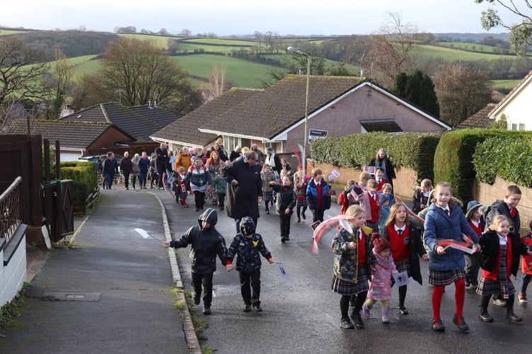 The procession passing houses in the village