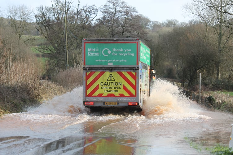 A Mid Devon District Council recycling lorry wading through floodwater at Creedy Bridge