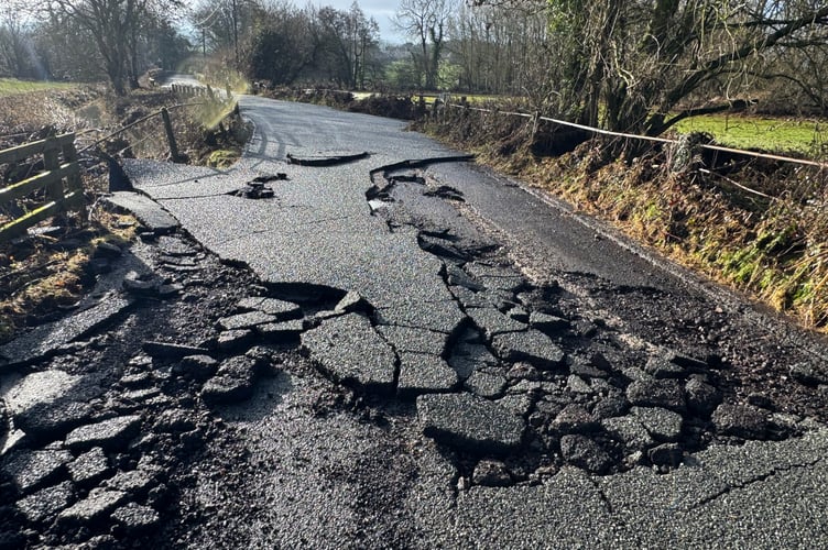 Where the road surface has been badly damaged by floodwater in Station Road, Newton St Cyres.  AQ 3193
