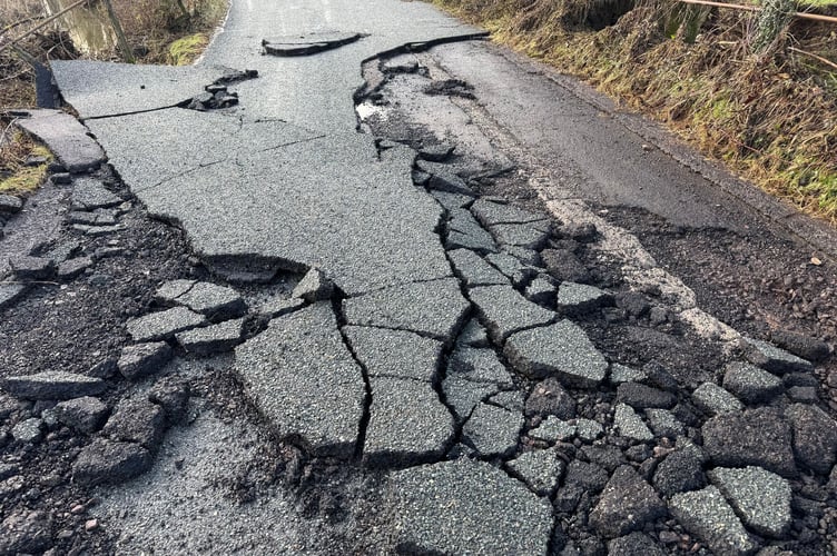 A badly damaged section of road in Station Road, Newton St Cyres. AQ 3200