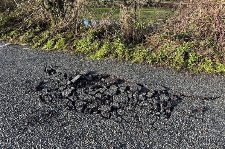 An area of damaged road surface at Station Road, Newton St Cyres.  AQ 3195
