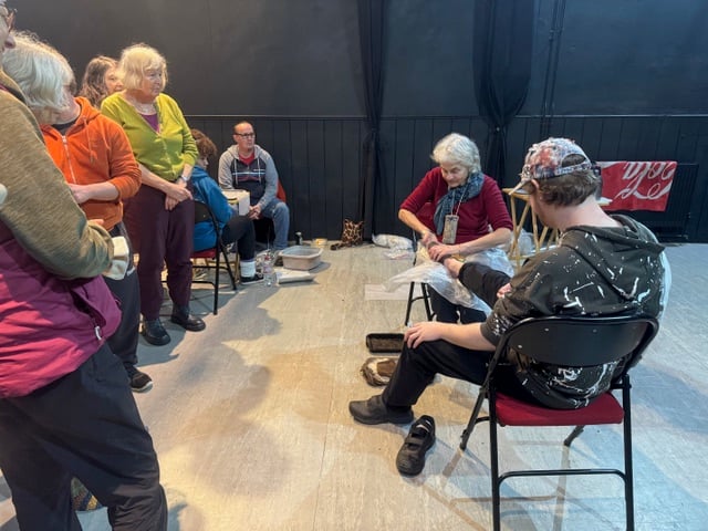 Artist Yuli Somme demonstrated how to wrap the foot on one of the participants.