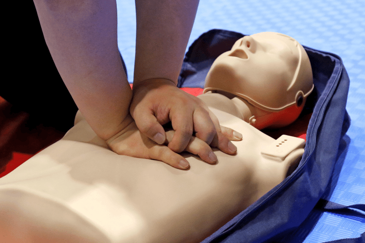 Person learning CPR on doll