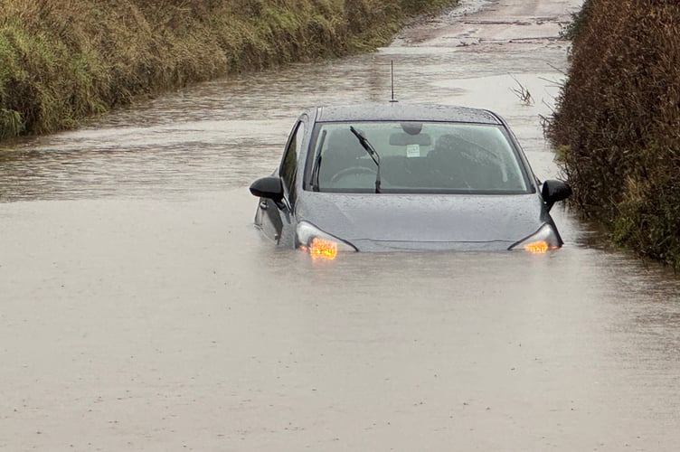 The car stuck in floods on Monday, February 9, with its lights on, at Yeoford Chapel.  AQ 4231
