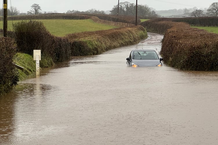 The vast expanse of deep floodwater with stranded car at Yeoford Chapel on Monday, February 9.  AQ 4219
