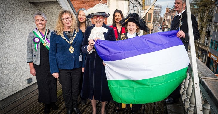 The suffragette flag being raised over Exeter Guildhall.
