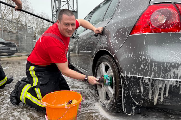 Hard at work cleaning the wheels on a car.  AQ 5820
