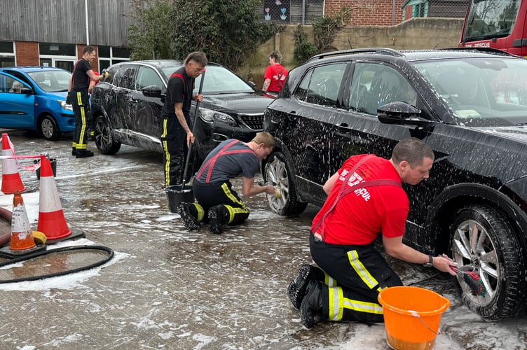Firefighters hard at work on the long line of cars at the charity car wash.  AQ 5856

