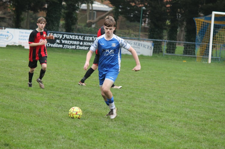 A Crediton player about to kick the ball. AQ 1104