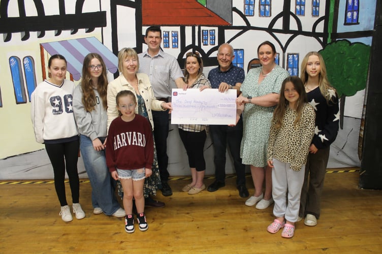 Tedburn Amateur Dramatic Society officers and some of the younger members presented £350 from the recent pantomime to Rachel Stevens, third right, for The Deaf Academy. AQ 1168