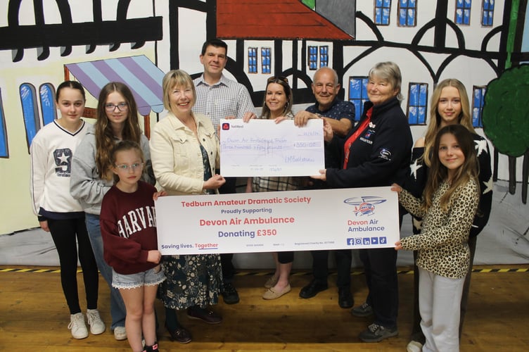 Tedburn Amateur Dramatic Society officers and some of the younger members presented £350 from the recent pantomime to Marilyn MacQueen, third right, for Devon Air Ambulance.  AQ 1171
