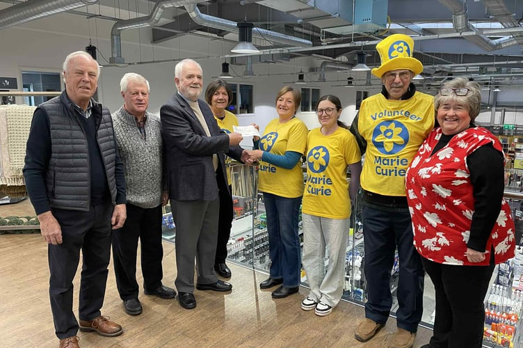 Gill Pearn receives the cheque for Marie Curie from Worshipful Master Alan Stanistreet of the Crediton Masonic Club, with other Freemasons and Hazel Evely, Morrisons Community Champion, right.
