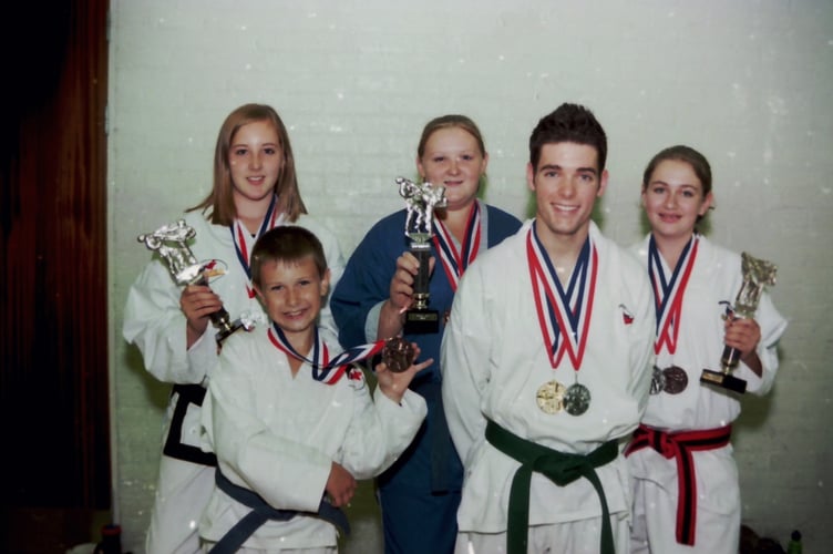 Members of Dave Powlesland's PUMA Tae Kwon Do class with a clutch of medals won at two tournaments in September 2005. DSC01272