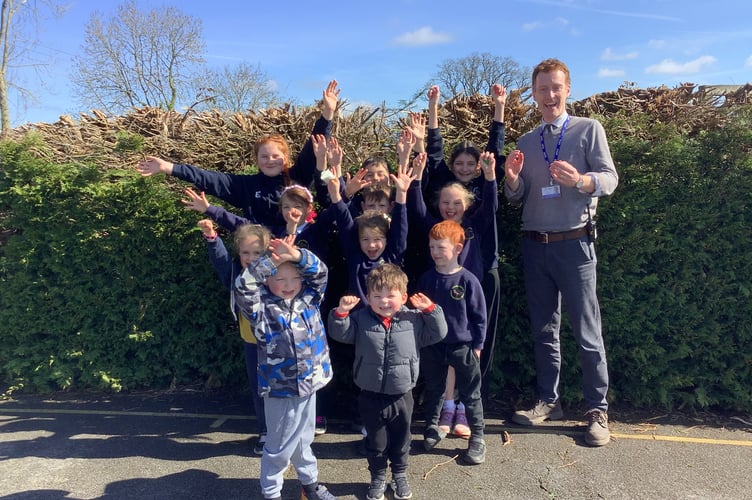 Cheriton Bishop Community Primary School Head Teacher Alex Cross and some of the pupils celebrate a highly positive Ofsted.

