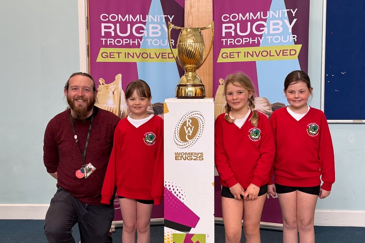 St Thomas of Canterbury CE Primary School Teaching Assistant Leigh Pooley with some of the school pupils at the trophy. AQ 7449