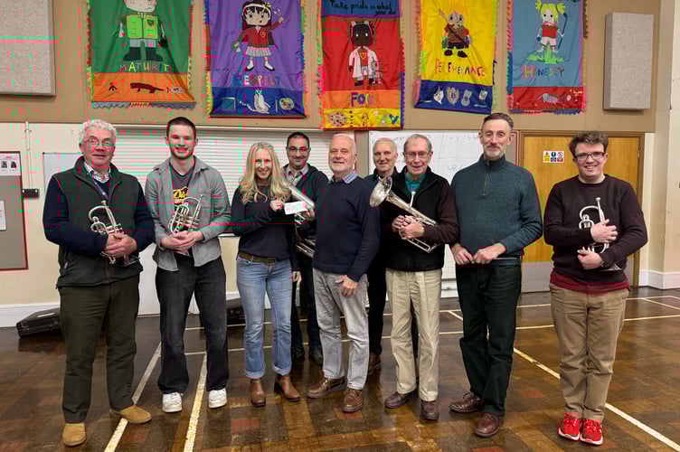 Chris Richards, Crediton Town Band chairman, centre, presenting £370 to Alison Goldby for Crediton Youth Orchestra. AQ 6962