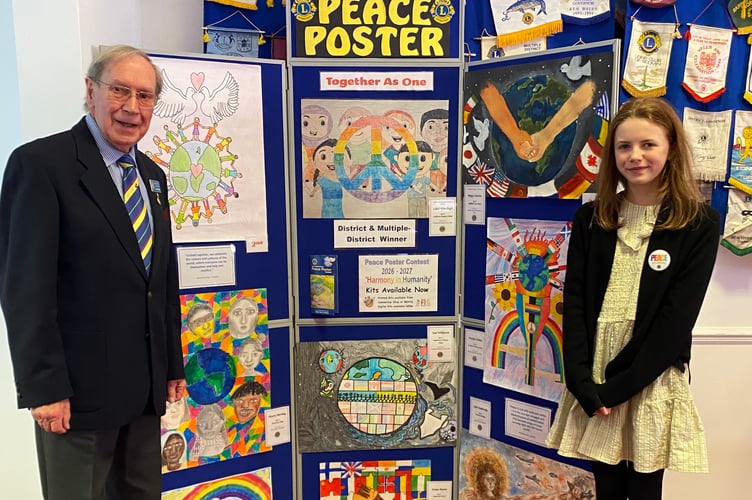 Lion Eric Parkes and National Lions Peace Poster competition winner Lilah, with her poster, centre.

