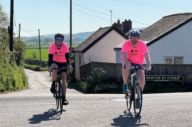 Cycling through Newton St Cyres.  AQ 8753
