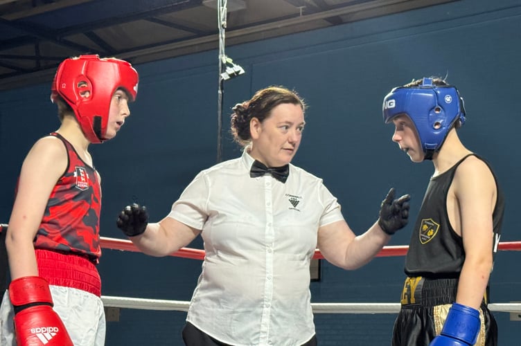 The referee has a word with two of the boxers. AQ 9371