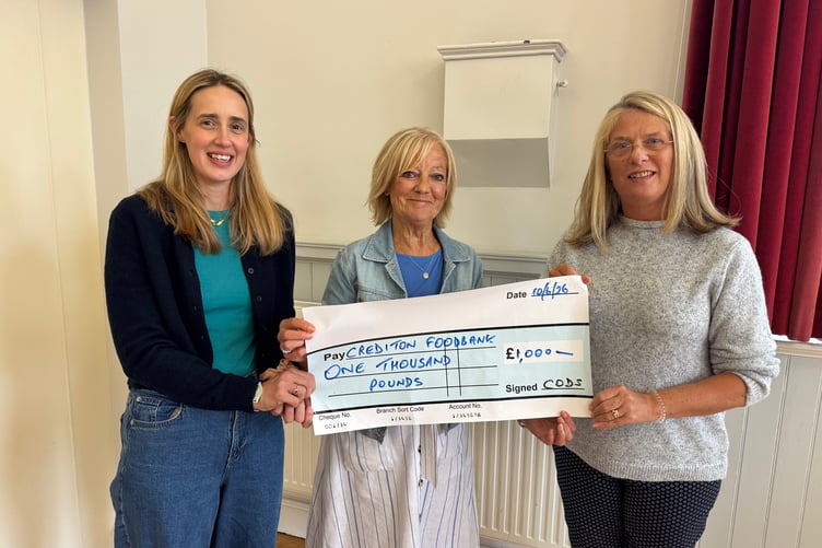 Carol Stoyle, centre, president of CODS, presents £1,000 to Crediton Foodbank representatives. AQ 2899