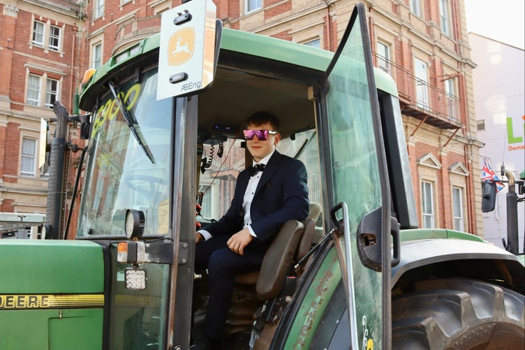 A cool youngster sporting shades in a tractor cab