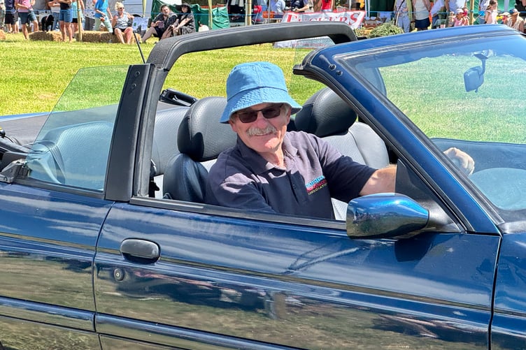 Andrew Green driving a car in the parade in the main ring. AQ 4078