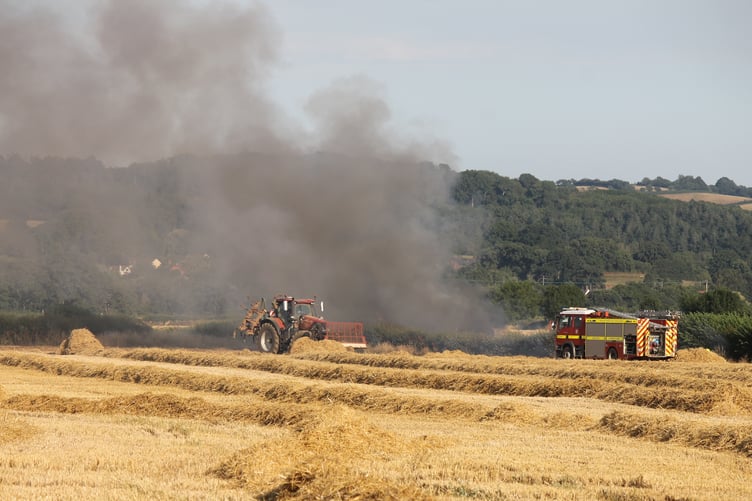 Farmers and firefighters at the scene of the fire. AQ 1586