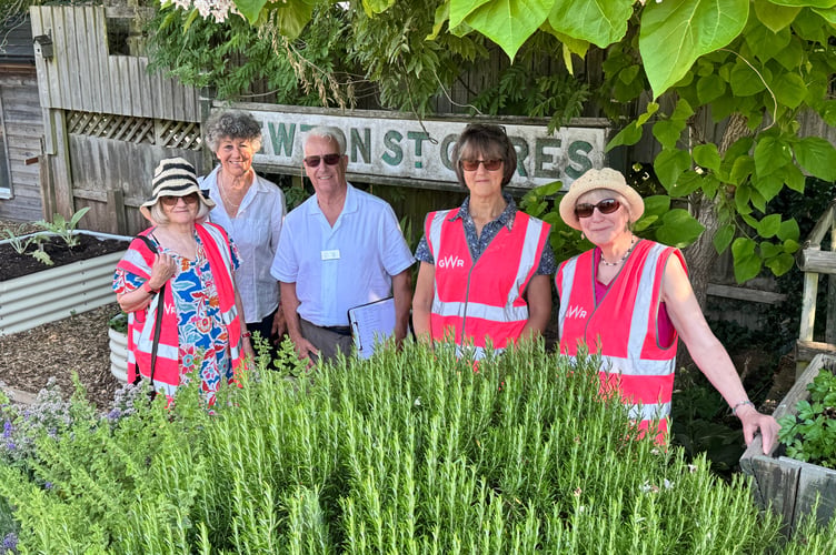Mr Ollier from South West in Bloom with Christine Fraser, second left and Newton St Cyres Railway Station garden volunteers. AQ 4919
