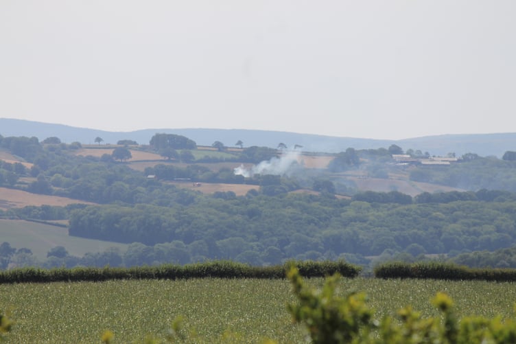 Smoke from the fire at Woodland Head can be seen from many miles away, a Devon Air Ambulance also visible. AQ 1749