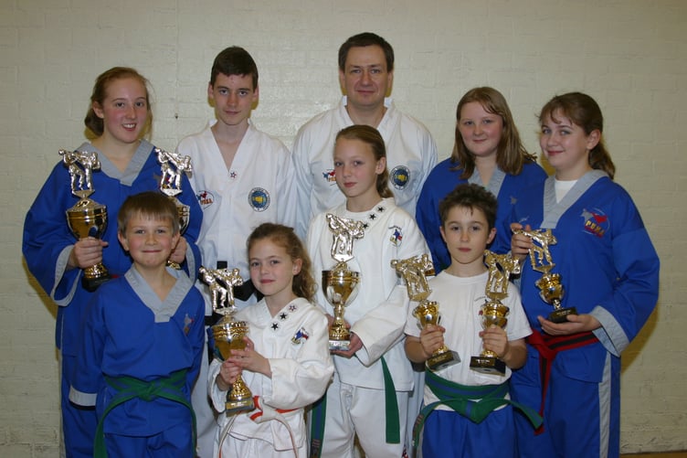 Members of Crediton PUMA Taekwon-Do group with many trophies won at a British Open Tournament, with instructor Dave Powlesland (back centre) in March 2004. 179-7936_IMG