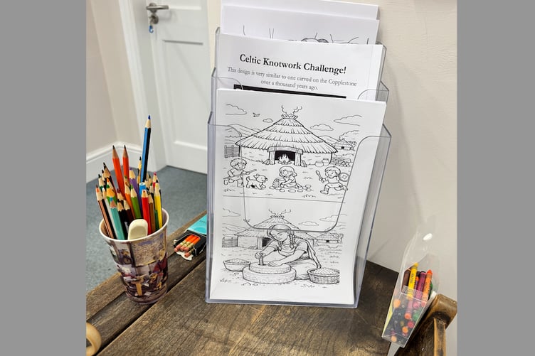 There are old school desks for children to enjoy colouring at Crediton Museum. AQ 8654