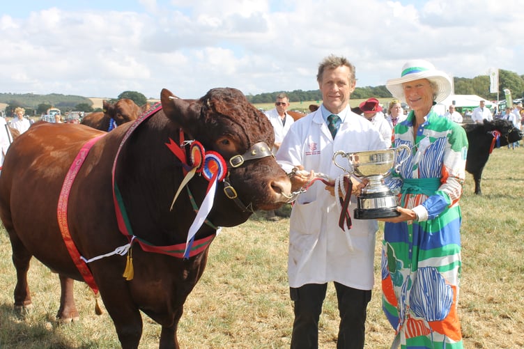 John May of Crediton won the Supreme Championship with his Devon bull Priorton Yeoman, pictured receiving the Championship trophy from North Devon Show President Grania Phillips. AQ 1836