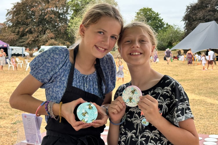 Two young people with coasters they painted at Arts in the Park. AQ 9026