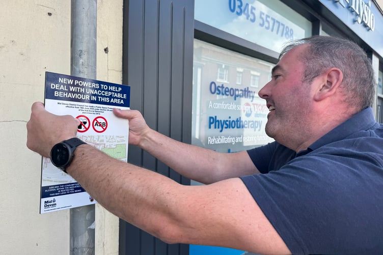 Andrew Green, District Officer, Mid Devon District Council, fitting one of the PSPO signs. AQ 9309