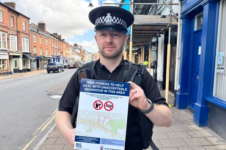 Mid Devon Police Inspector Mark Arthurs with one of the PSPO signs in Crediton High Street. AQ 9328