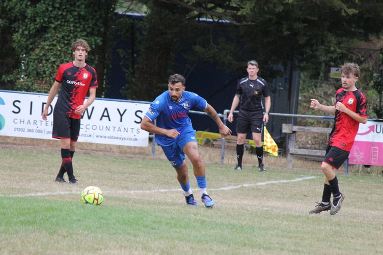 Crediton with the eye on the ball with two Bridport players watching on. AQ 2136
