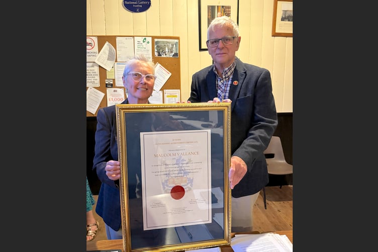 Cllr Gwen DuChesne MBE, Cabinet Member for Parish and Community Engagement at Mid Devon District Council, with the Outstanding Achievement Certificate presented to Malcolm Vallance. AQ 9991
