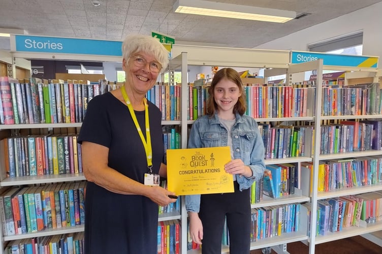 Customer Service Assistant Alison Littlejohn presenting Esme with her gold certificate