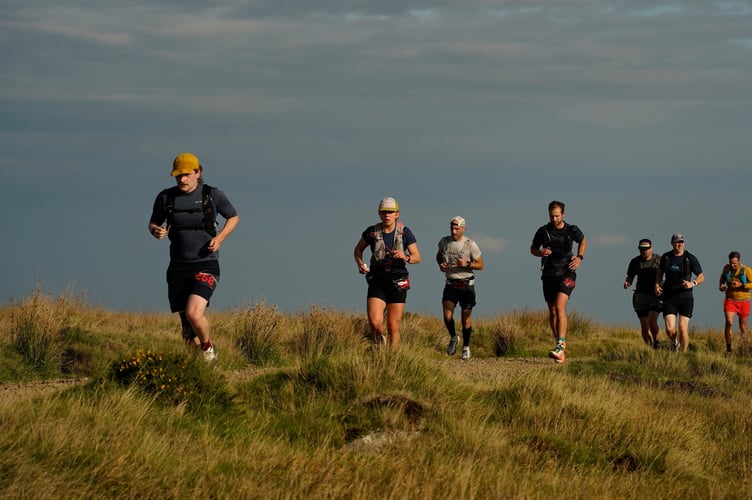 Dartmoor Beast trail runners cross moorland.
