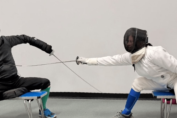 A seated lesson between coach and fencer